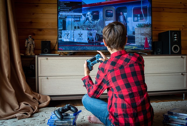 Un garçon jouant à la console dans sa chambre