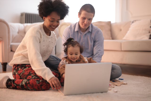 Des parents regardant un dessin animé avec leur fille.