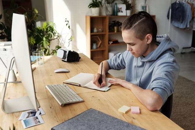 Un collégien faisant ses devoirs dans sa chambre