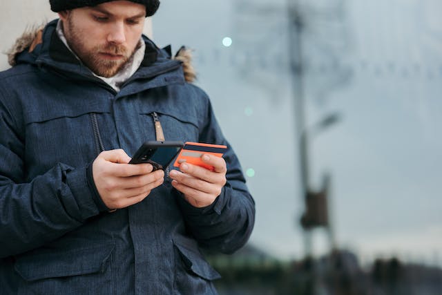 Un ado réalisant un achat en ligne avec sa carte bancaire.