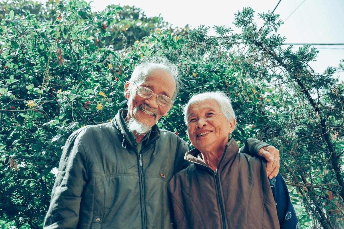 Un grand parent et sa compagne dans leur jardin.