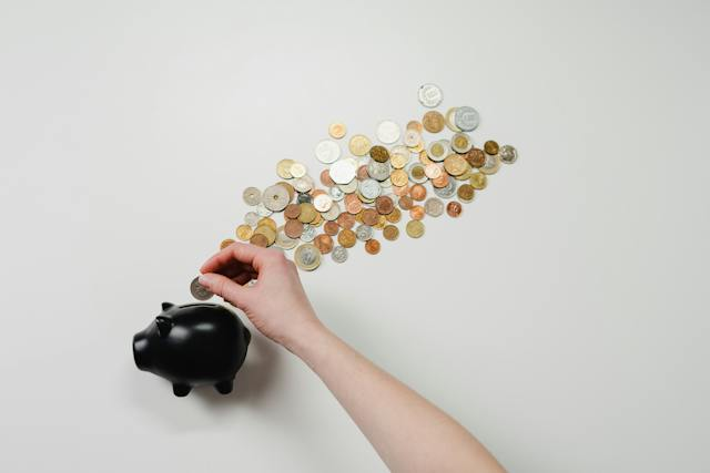 Une personne ajoutant ses économies dans une tirelire.